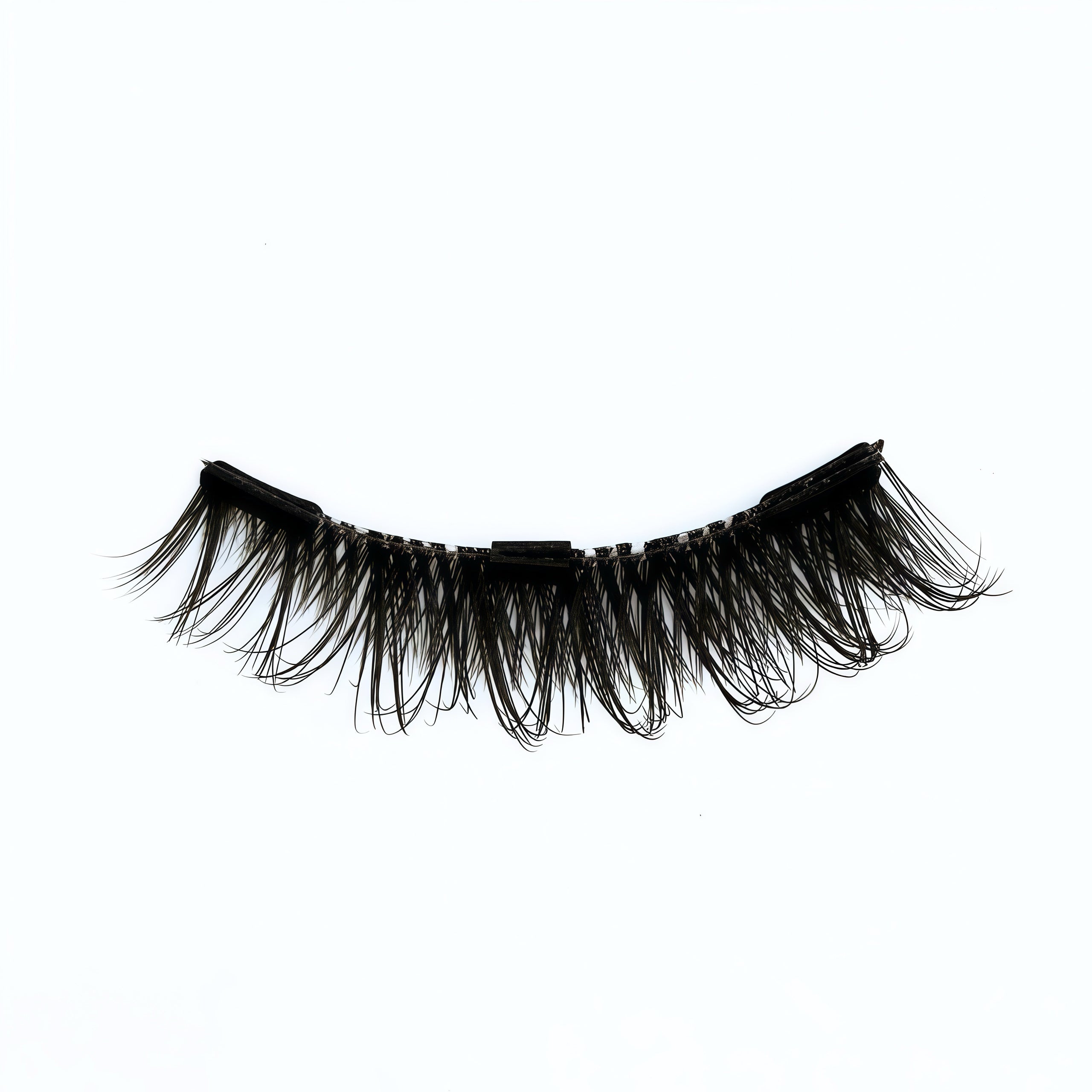Close-up of the ‘Jade’ lash style on a white background, showing black false eyelashes with a voluminous cat-eye shape.